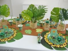 the table is set with plates and place settings for an animal themed birthday party or baby shower