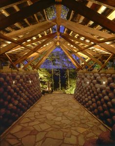 the inside of a wooden structure with stone floors and lights on each side of it