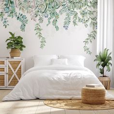 a bed with white sheets and pillows in front of a green plant mural on the wall