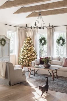 a living room filled with furniture and a christmas tree in the middle of the room