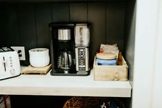 there is a coffee maker on top of the shelf next to some other kitchen items