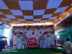 a stage set up with flowers and curtains for a wedding or other function in an indoor venue