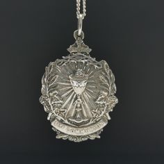 "A magnificent antique Catholic Communion medal, Art Nouveau period French religious holy medal, hallmarked, blank on reverse, in good used condition. A fairly rare religious holy medal, nice size, ideal for protection necklace, would make a nice gift for someone special! Floats from a 22 inch long 925 silver chain! Material: solid silver, hallmarked total weight: 10.5g Measures: approx 26 x 37 mm (1 x 1.5\" inch) A stunning religious shop well worth a visit ... https://etsy.me/2HAqjdY" Commemorative Coin Pendant, Engraved Coin-shaped Spiritual Jewelry And Charms, Spiritual Engraved Medallion Locket Necklace, Engraved Spiritual Medallion Jewelry, Engraved Cross Pendant For Commemoration, Engraved Round Pendant For Commemoration, Silver Engraved Necklace For First Communion, Engraved Silver Necklace For First Communion, Miraculous Medal Medallion Necklaces For Commemoration