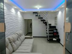 a living room with a white couch and stairs