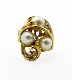 "14K Yellow Gold Cultured Pearl and Diamond Ring Size 6.25 Pearl is the birthstone for the month of June Diamond is the birthstone for the month of April Cluster size (top design of the ring): measures approximately 20 mm X 15 mm 3 Akoya Cultured Pearls measuring between 6 and 7 mm - stem set - Color: White with light cream overtone - Surface: lightly blemished - Shape: round - Luster: good luster 3 round faceted diamonds at approximately 0.07 ct each - Total 0.21 ct - Color: G - H - Clarity: SI Anniversary Yellow Gold Multi-stone Pearl Ring, Heirloom Multi-stone Pearl Ring For Anniversary, Unique Three Stone Jewelry For Anniversary, Formal Cluster Birthstone Jewelry, 25 June, Pearl And Diamond Ring, Light Cream, Multi Stone Ring, Top Design