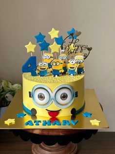 a yellow birthday cake with blue stars and minion decorations