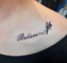 a woman with a small tattoo on her shoulder that says believe and a tinkerbell