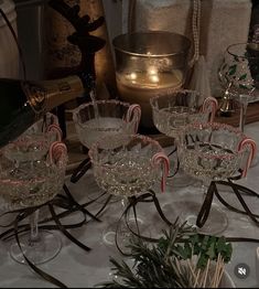 wine glasses with candy canes in them sitting on a table next to other glassware