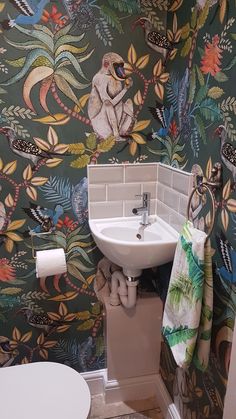 a bathroom with floral wallpaper and white sink