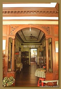 the inside of a building with wooden floors and columns