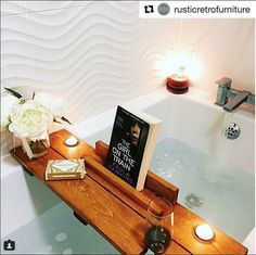 a bathtub with candles and a book on it