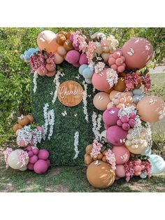 the balloon arch is decorated with flowers and balloons