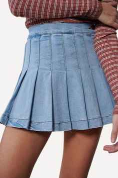 Denim mini skirt featuring pleats all round, one button on the side of the waist, and an invisible side zip closure. Crafted with slightly stretchy cotton fabric. -High waistline.-Side button and zip closure.-Pleated front and back.-99% Cotton 1% Spandex. Size Guide -The model is wearing a size Small.-The model is 5'8" tall.-Length of size Small is 14"-WAIST S 24-26" M 26-28" L 28-30" Shipping ﻿-Ships from the US within 5-7 days. Medium Wash Mini Cotton Skort, High Waist Cotton Mini Skirt With Lining, High Rise Stretch Cotton Skort, Trendy Mini Cotton Skort, Trendy Mini Length Cotton Skort, Trendy Cotton Mini Skort, Cotton Mini Length Skort In Medium Wash, Trendy Fitted Mini Hem Tennis Skirt, Fitted Denim Mini Shorts