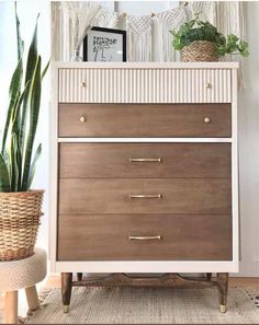 a white and brown dresser with plants on top