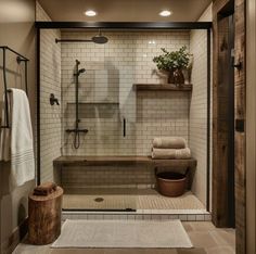 a walk in shower sitting next to a wooden bench