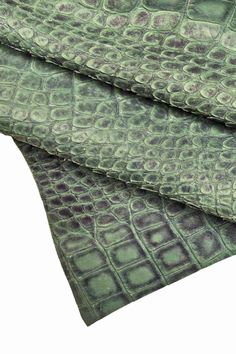 the green and purple fabric is folded on top of each other, with an intricate pattern