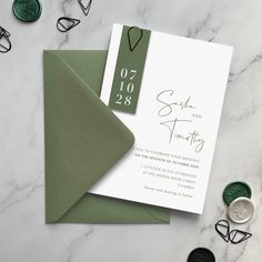 the wedding stationery is laid out on a marble table