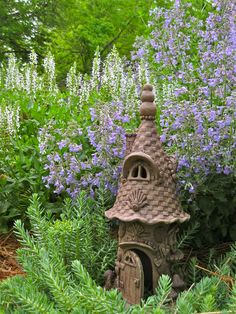 a bird house in the middle of some flowers