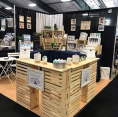 a booth at a book fair with wooden crates on the floor and bookshelves in the background