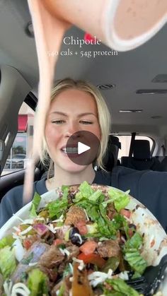 a woman holding a plate of food in the back of a car