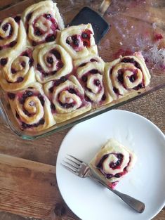 a white plate topped with pastries next to a glass baking dish filled with fruit