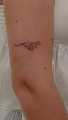 a woman's arm with a small tattoo of a cheetah