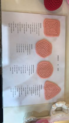 three crocheted hearts are displayed on a piece of paper