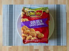 a bag of golden crispy crowns sitting on top of a white and blue plate