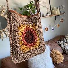 a crocheted bag hanging from a hook on a wall in a living room