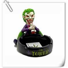 the joker statue is sitting on top of a trash can