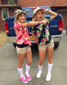 two girls are standing in front of a truck