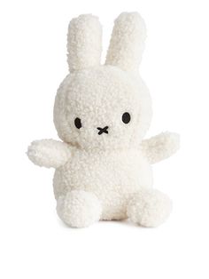 a small white stuffed animal with black eyes