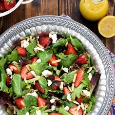 a salad with strawberries and feta cheese in a bowl on a wooden table