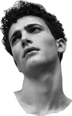 a black and white photo of a young man with curly hair looking up at the sky