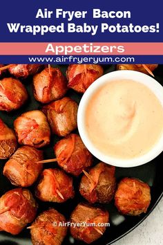 air fryer bacon wrapped baby potatoes on a black plate with dip in the middle