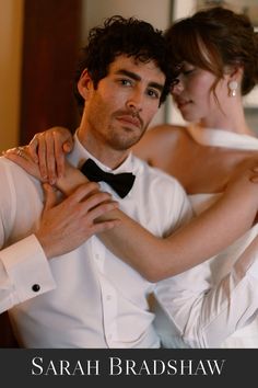 a man in a tuxedo is helping a woman put on her bow tie