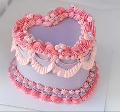 a heart shaped cake with pink and purple icing