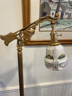 a lamp that is on top of a stand in front of a wall with pictures