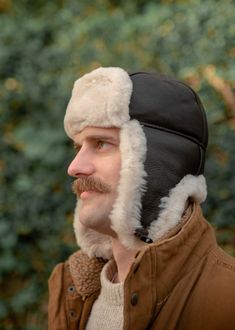 A beautifully crafted genuine sheepskin trapper hat that is both practical and stylish. Made with soft Nappa leather bound with a genuine real sheepskin inner, sheepskin sides and sheepskin ear detail. The ear flaps can be clipped together either under the chin for cold weather or over the top for less windy days. Machine washable. Hand wash Only. Sizes. Medium - 60cm. Large - 62cm. XLarge - 64cm. All Photographs and illustrations including but not limited to size and care guides are protected by copyright of the owner Lambland Limited. Copying, altering and using this copyrighted material will result in legal action. Images not owned by Lambland have been licensed for use through the creator. Hat With Ear Flaps, Leather Workshop, Trapper Hats, Ear Hats, Luxury Blanket, Dark Brown Color, Windy Day, Mens Luxury, Skull Cap Beanie