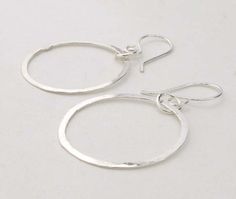 "Lightweight dangling hoop sterling silver earrings. Simple and delicate these are a perfect compliment to a casual jean day, yet a perfect accessory for a dressy evening out. Very versatile jewelry for everyday wear. We will send them boxed and ready to give as a gift. Measures: 1 1/8\" diameter Length: 1 3/4\" Made to order. Please allow up to 14 business days for fabrication before shipment. VISIT OUR SHOP: http://PoseidonsBooty.etsy.com SHOP POLICIES: http://www.etsy.com/shop/PoseidonsBooty/ Simple Sterling Silver Hoop Jewelry, Simple Sterling Silver Dangle Hoop Earrings, Simple Adjustable Sterling Silver Hoop Earrings, Sterling Silver Hoop Earrings With Ear Wire, Small Hoop Sterling Silver Earrings With Lever Back, Everyday Handmade Silver Hoop Earrings, Sterling Silver Drop Hoop Earrings With Lever Back, Minimalist Sterling Silver Dangle Hoop Earrings, Small Hoop Hammered Sterling Silver Jewelry