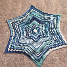 a blue and white crocheted star on the ground