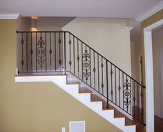 a stair case with wrought iron railing and wood flooring