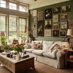 a living room filled with furniture and lots of pictures on the wall above it's windows