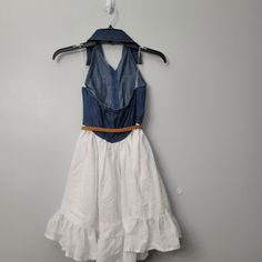 Zunie Unikids' Sleeveless Denim Halter Vest Dress In Blue/ White Denim And A Tiered Textured Cotton Combine To Create The Perfect Dress For Your Little One. Spread Collar Sleeveless Button Front Belted Waist Tiered Skirt 100% Cotton Machine Wash Cold, Tumble Dry Low Approx Measurements Size 10 Pit To Pit 13" / 26 Length 31" Size 14 Pit To Pit 14" / 28" Length 32" White Denim Dress For Summer, White Denim Summer Dress, White Fitted Denim Vest, Fitted White Denim Dress, White Fitted Denim Dress, White Sleeveless Cotton Denim Dress, White Sleeveless Denim Dress For Spring, White Sleeveless Denim Vest For Spring, White Sleeveless Denim Vest For Summer