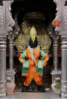 the statue is dressed in an orange and green outfit