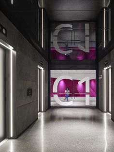 the entrance to an office building with pink and white letters on the wall behind it