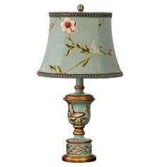 a lamp with a flower on it and a blue shade over the light is sitting on a white surface