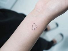 a small tattoo on the wrist of a woman's left arm with a heart