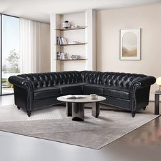 a black leather sectional sofa sitting on top of a white rug