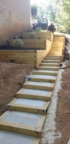 the steps are made out of wood and have cement blocks on each side, along with gravel in between them